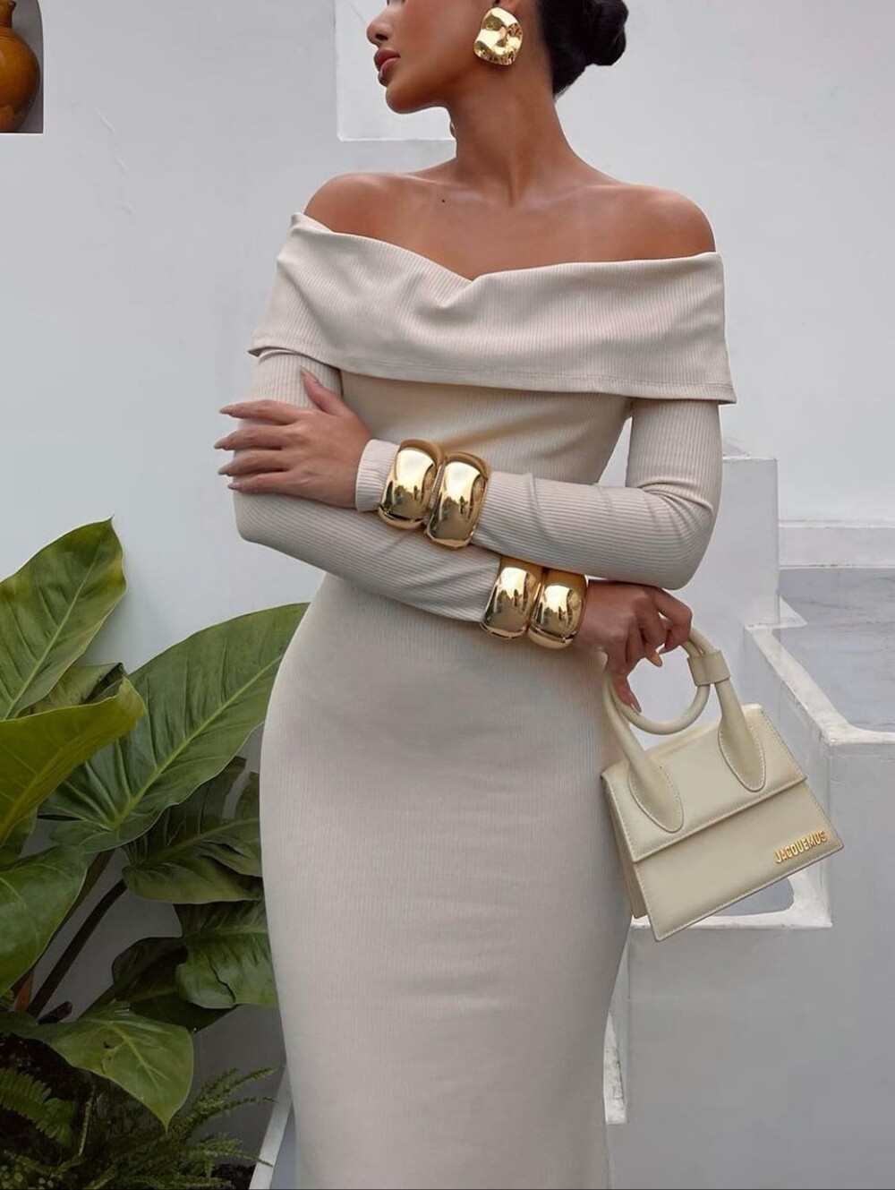 A fitted knit maxi dress in a delicate cream color that emphasizes the silhouett